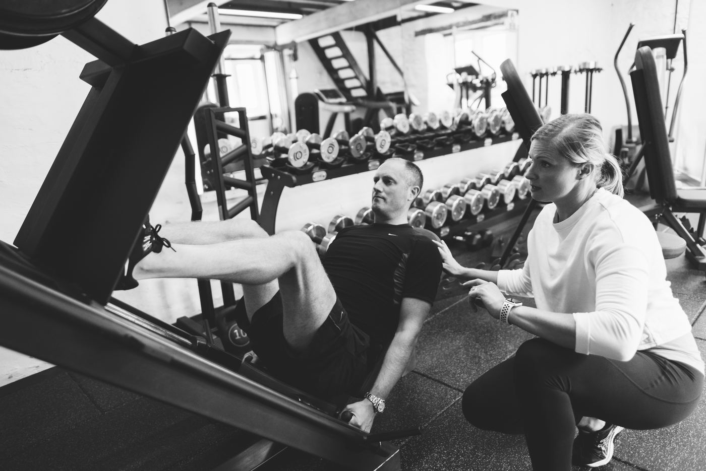 Jo coaching a client on the leg press